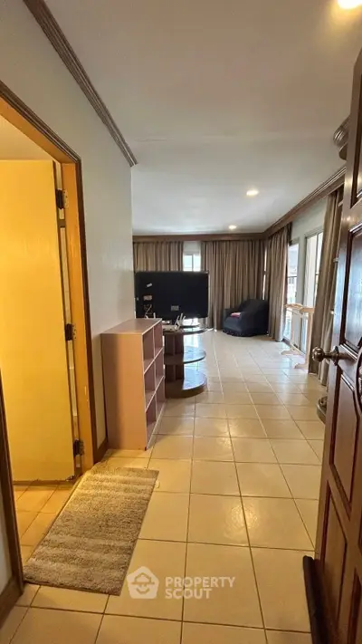 Spacious living room with tiled flooring and modern furnishings