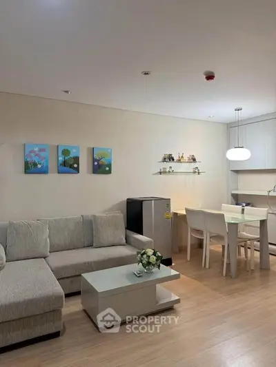 Modern living room with cozy sofa, dining area, and stylish decor in open-plan apartment.