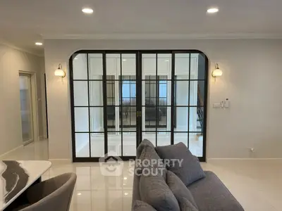 Spacious living room with elegant glass doors and modern lighting