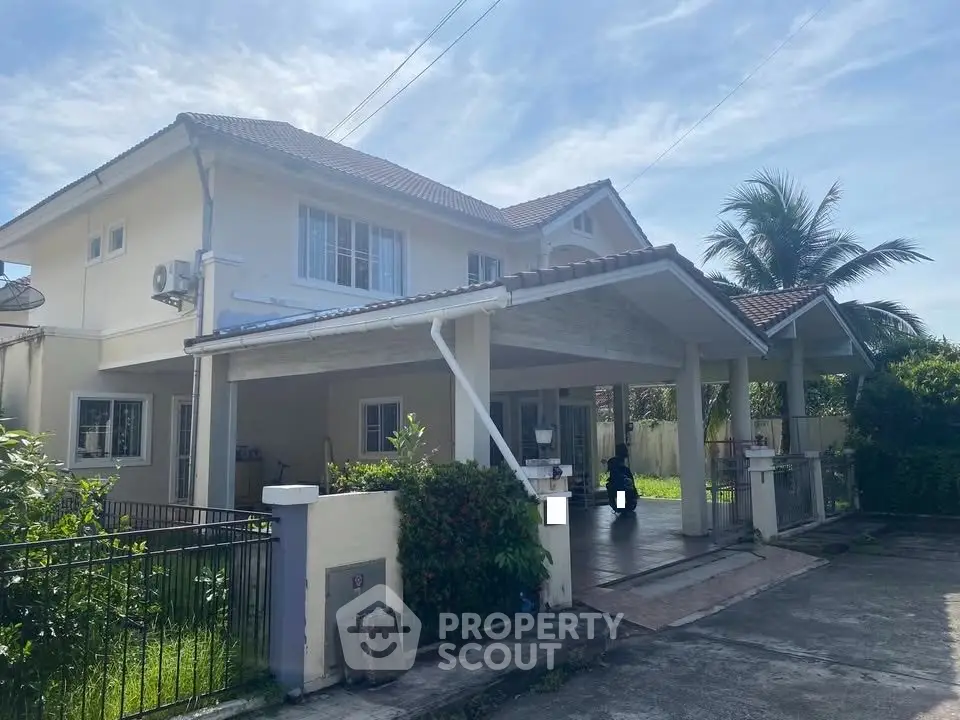 Charming two-story house with spacious driveway and lush greenery, perfect for family living.