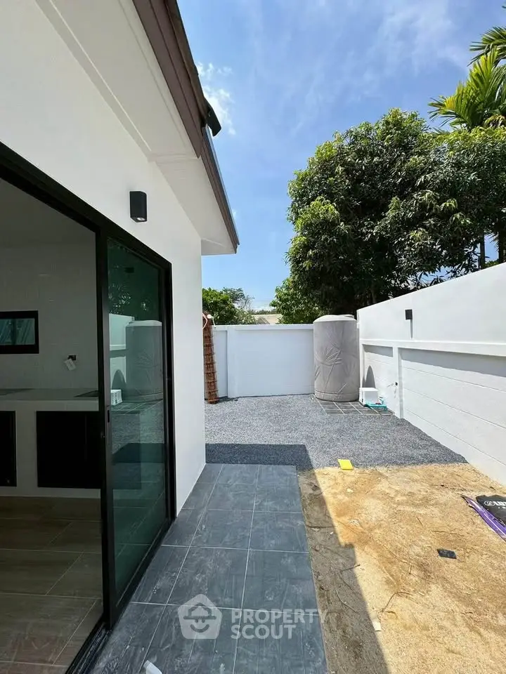 Modern exterior view of a stylish home with sliding glass doors and spacious outdoor area.