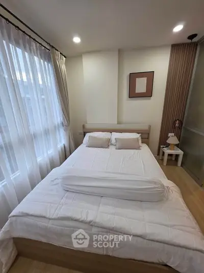 Cozy bedroom with natural light and modern decor, featuring a comfortable bed and stylish furnishings.
