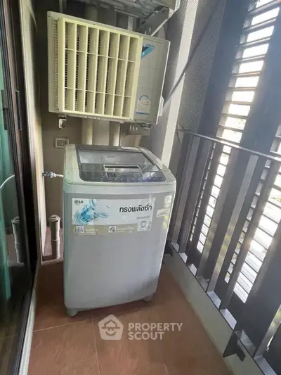 Compact balcony with washing machine and air conditioning unit, ideal for urban living.