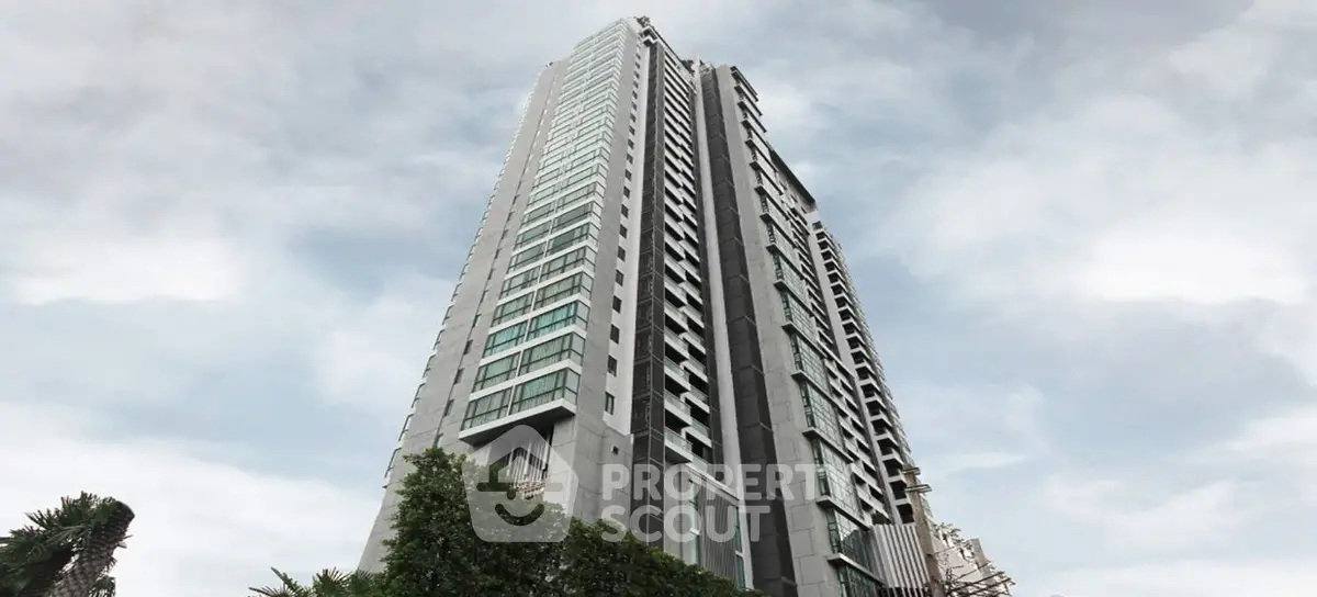 Stunning high-rise building with modern architecture and lush greenery at the base.