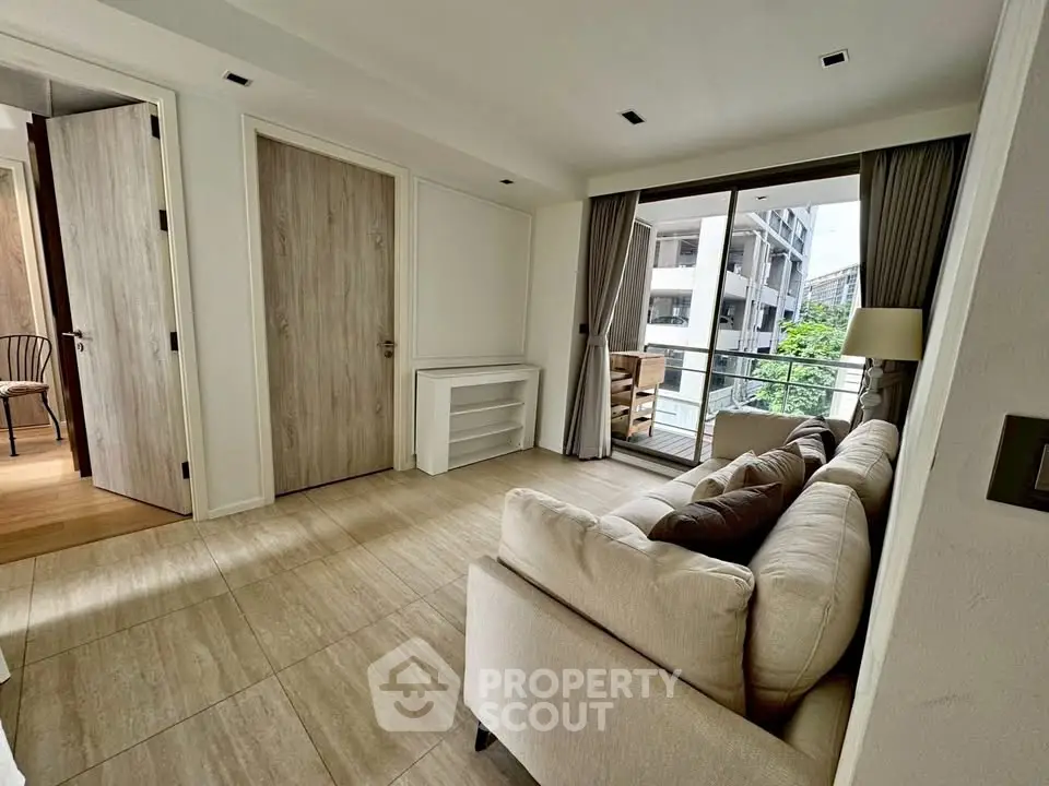 Spacious living room with modern decor and balcony view in a stylish apartment.