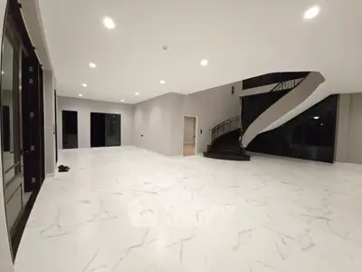 Spacious modern living room with elegant staircase and marble flooring