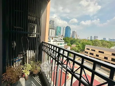 Charming balcony with city skyline view and potted plants, perfect for urban living.