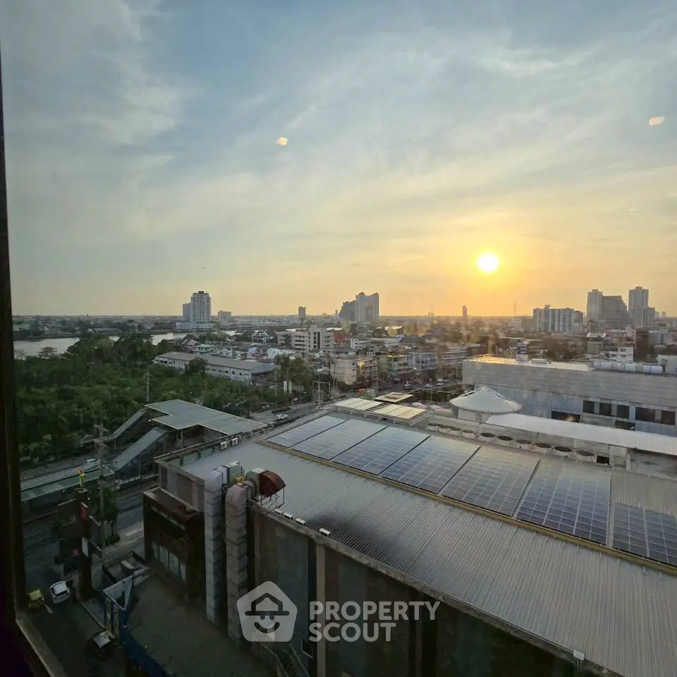 Stunning cityscape view from high-rise building at sunset, showcasing urban skyline and solar panels.