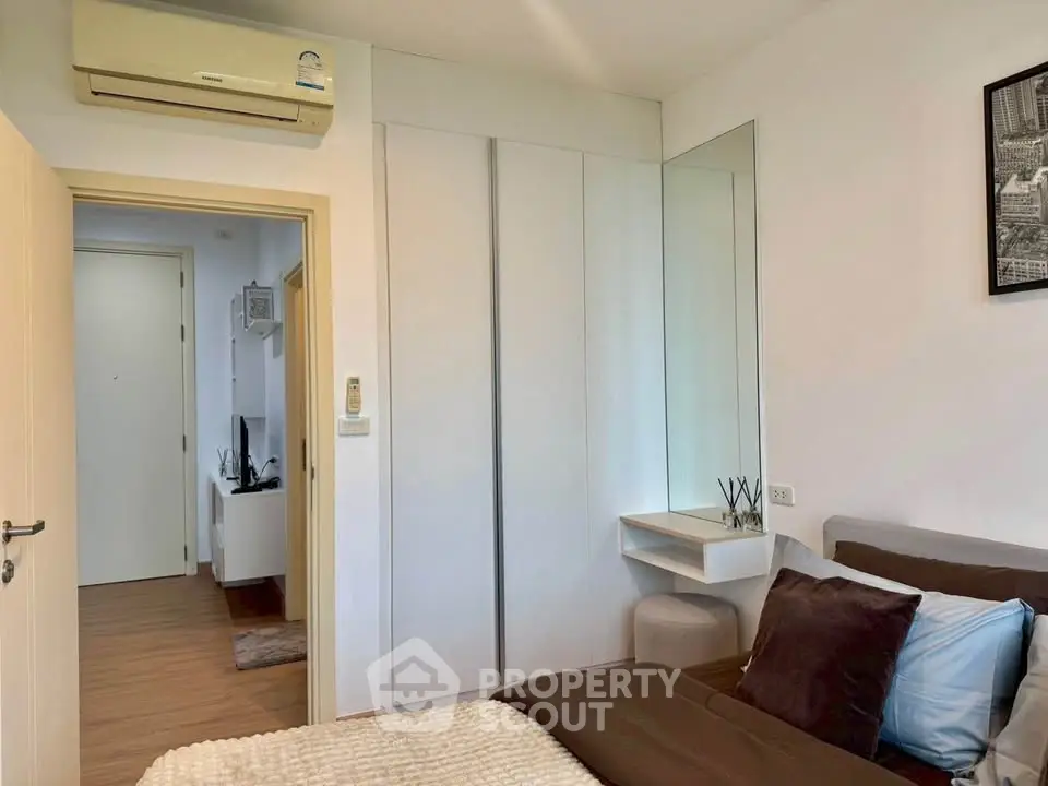 Cozy bedroom with modern decor and built-in wardrobe in a stylish apartment.