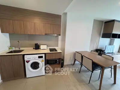 Modern kitchen with integrated appliances and dining area in stylish apartment