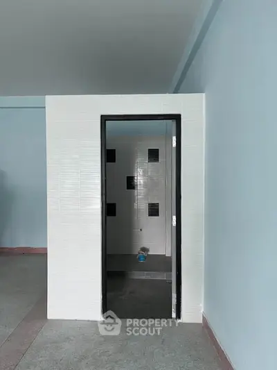Spacious interior with a modern tiled shower area, perfect for customization.