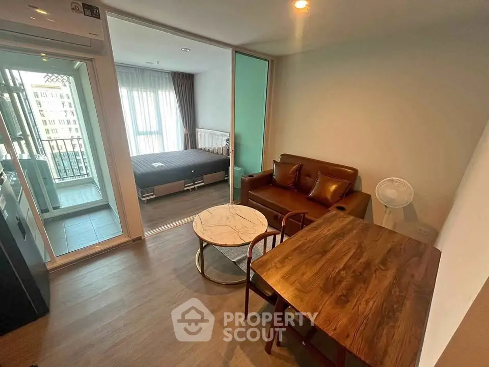 Modern apartment interior with cozy living room and bedroom, featuring a balcony view.