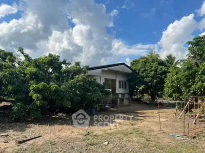 Charming rural house surrounded by lush greenery and open sky, perfect for nature lovers seeking tranquility.