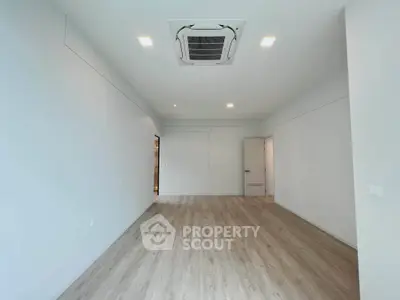 Spacious modern living room with sleek flooring and ceiling air conditioning unit.