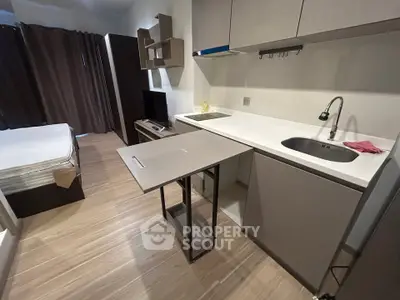Modern studio apartment with compact kitchen and cozy living space, ideal for urban living.