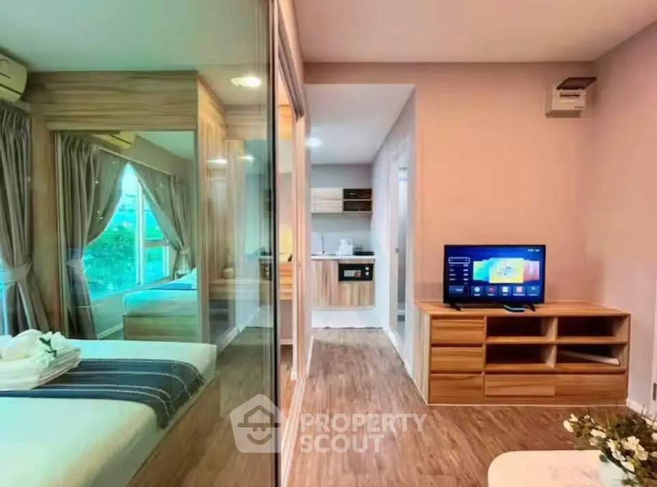 Modern apartment interior with glass partition, cozy bedroom, and stylish kitchen area.