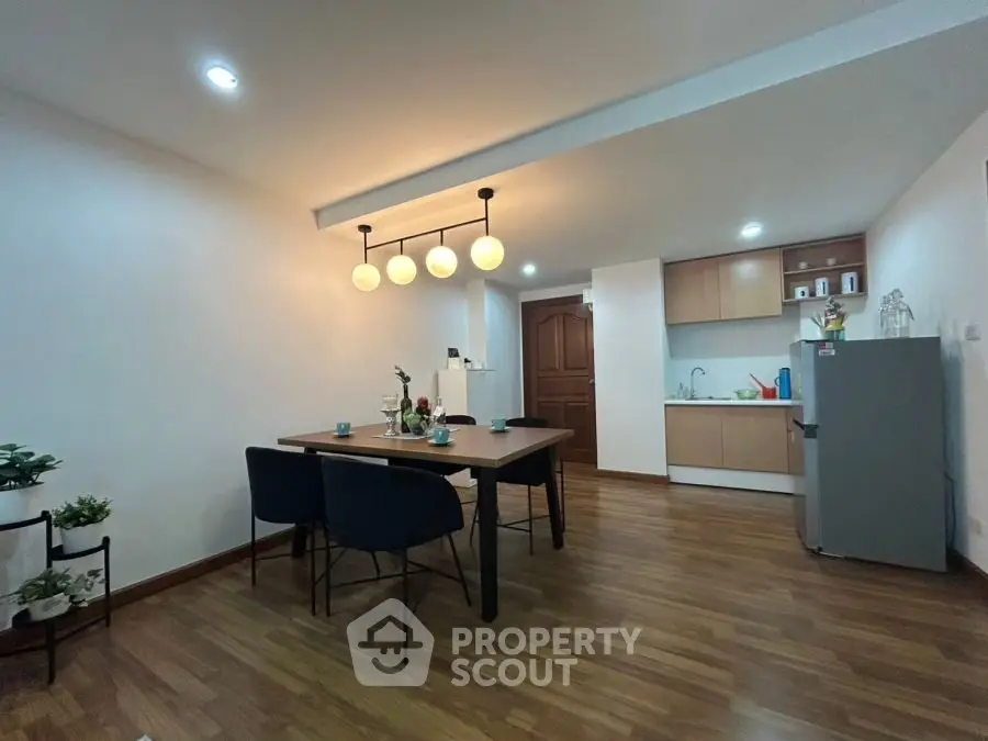 Modern dining area with stylish lighting and open kitchen layout.