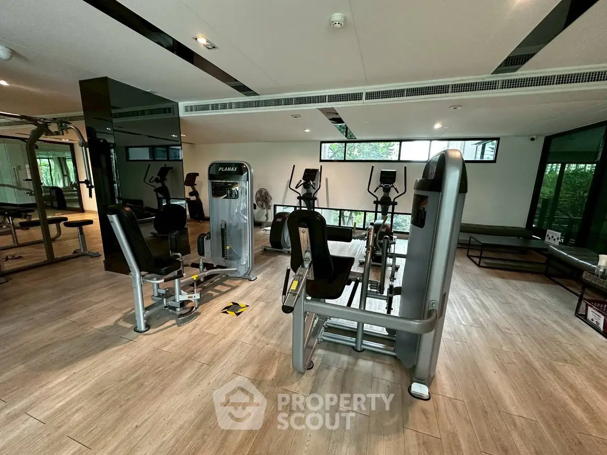 Modern gym with state-of-the-art fitness equipment and large windows for natural light.