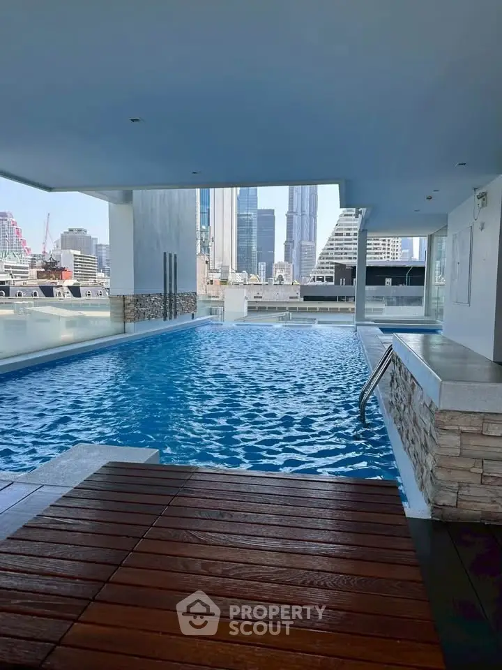 Luxurious rooftop pool with stunning city skyline view, perfect for relaxation and leisure.