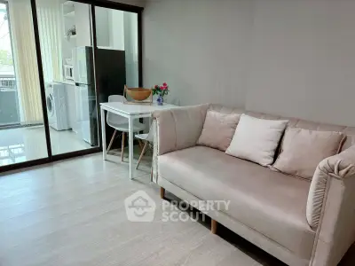 Modern living room with cozy sofa and dining area, featuring a washing machine and balcony view.