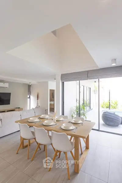 Modern dining area with natural light and stylish decor in open-plan living space.