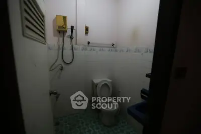 Compact bathroom with basic fixtures and tiled walls