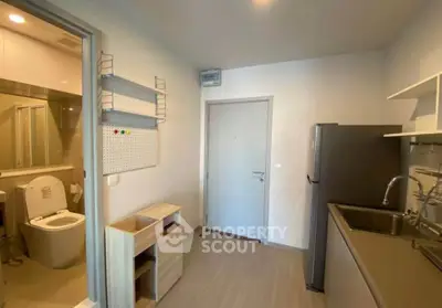 Compact apartment kitchen with modern appliances and adjacent bathroom