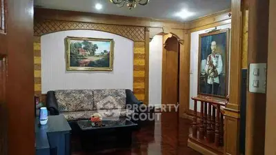 Elegant living room with classic decor and framed artwork, featuring a cozy seating area.