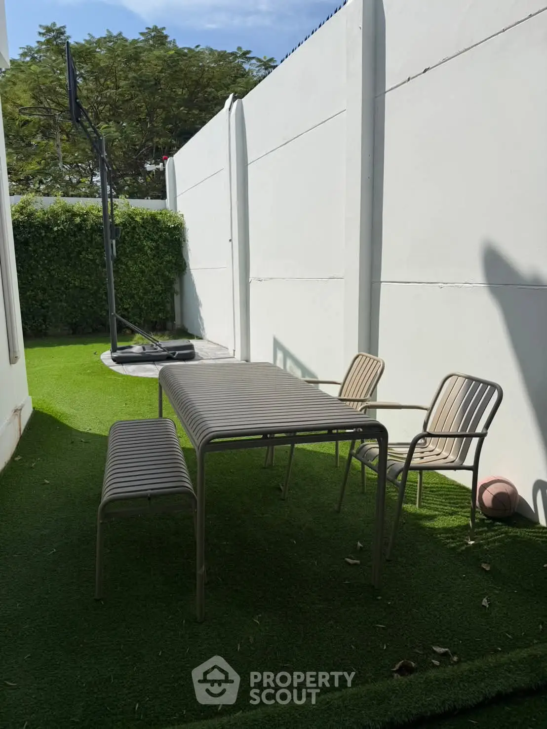 Charming outdoor garden area with modern seating and lush greenery, perfect for relaxation and entertaining.