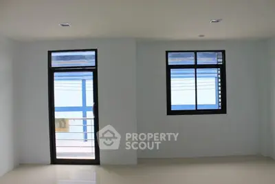 Spacious room with large windows and balcony access, ideal for natural light and modern living.