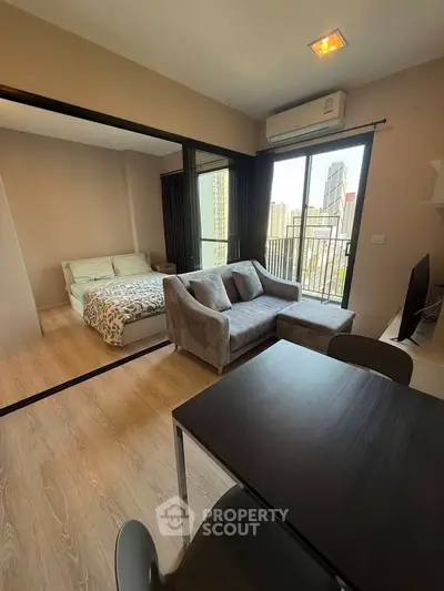 Modern studio apartment with city view, featuring cozy living area and bedroom.
