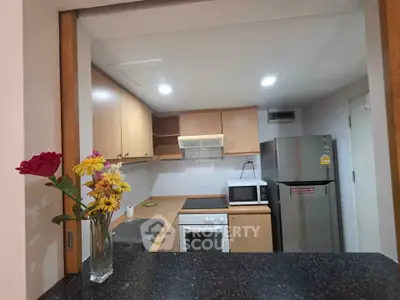 Modern kitchen with open layout, featuring wooden cabinets, stainless steel appliances, and elegant countertop.