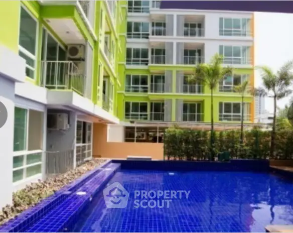 Modern apartment building with vibrant colors and a luxurious outdoor pool area.