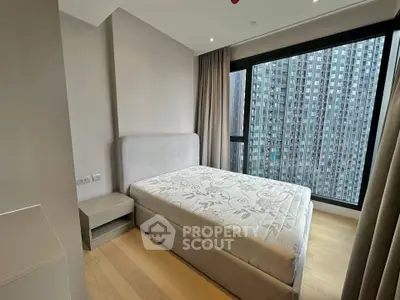 Modern bedroom with large window and city view in high-rise apartment