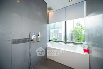 Luxurious bathroom with city view and modern bathtub in high-rise apartment.