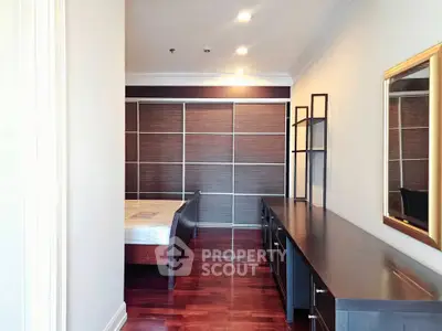Spacious bedroom with elegant wooden flooring and modern furniture