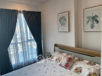 Cozy bedroom with floral bedding and large window with city view.