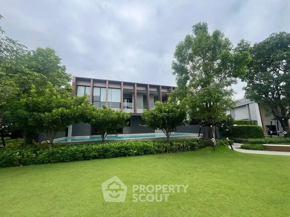 Modern luxury home with lush garden and pool, perfect for serene living.