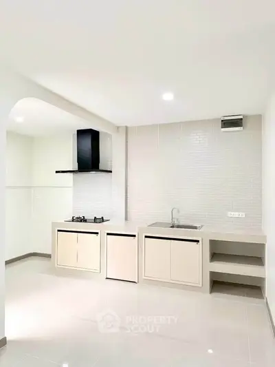 Modern kitchen with sleek design and gas stove in a bright, minimalist apartment.