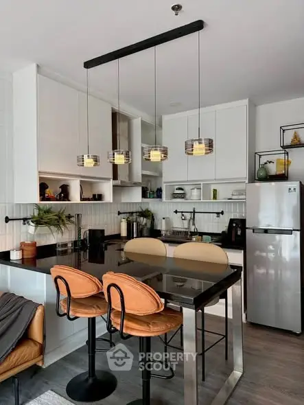 Modern kitchen with sleek design, featuring a breakfast bar and stylish pendant lighting.