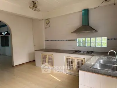 Spacious kitchen with modern gas stove and ample natural light