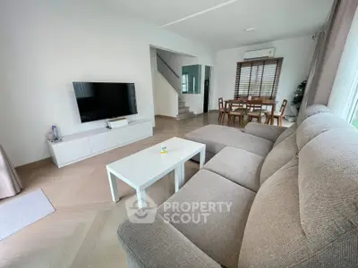 Spacious living room with modern decor and large TV, perfect for relaxation.