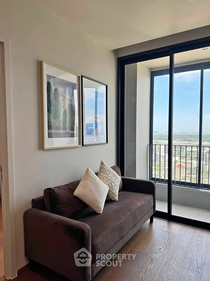 Modern living room with cozy sofa and stunning balcony view in high-rise apartment.