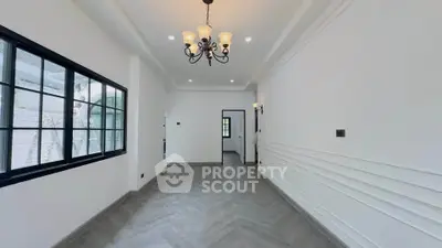 Spacious modern living room with elegant chandelier and large windows