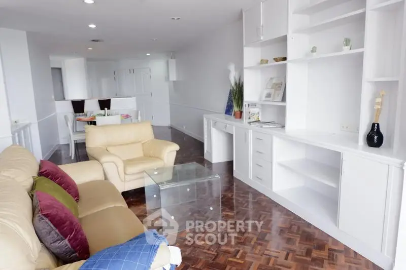 Spacious living room with modern furniture and built-in shelving, perfect for comfortable living.