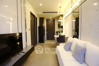 Modern living room with elegant decor and open layout, featuring a cozy sofa and stylish lighting.