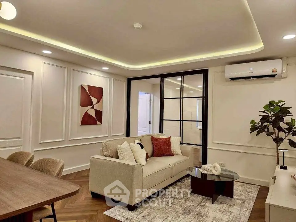 Elegant living room with modern decor, featuring a cozy sofa, stylish artwork, and ambient lighting.