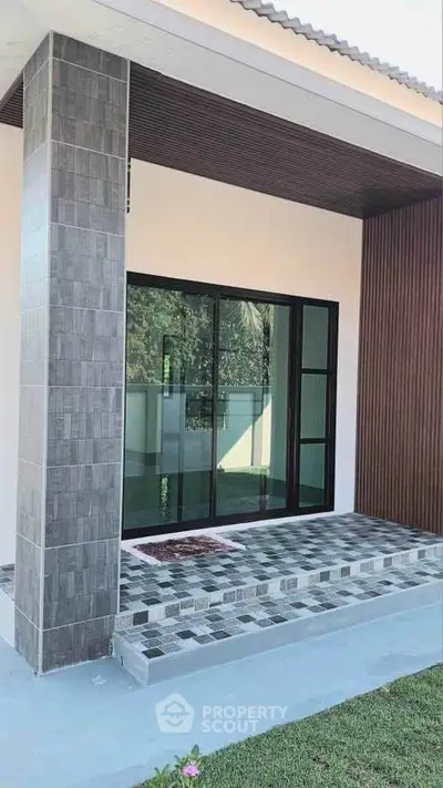 Modern house entrance with stylish tiled steps and large glass doors