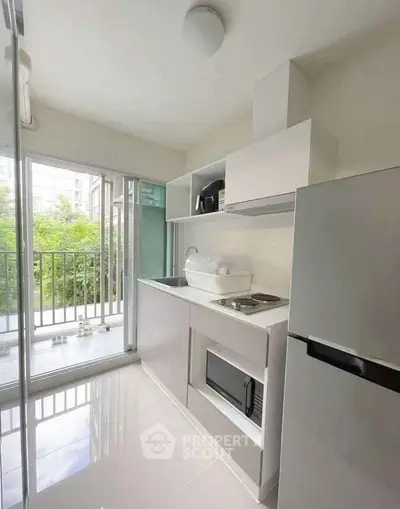 Modern kitchen with sleek appliances and balcony view, perfect for urban living.