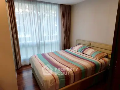 Cozy bedroom with large window and elegant curtains in modern apartment.